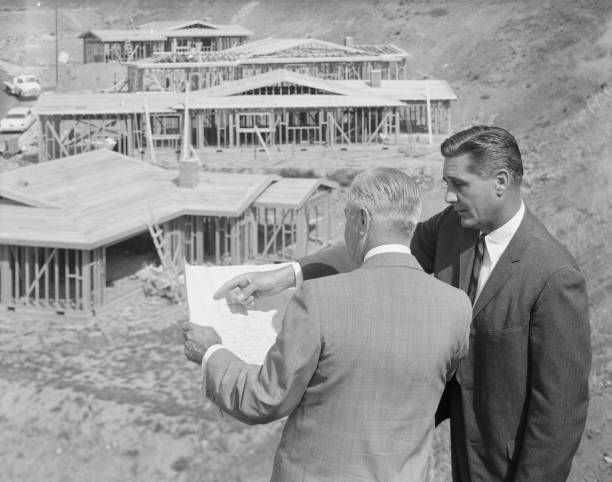 Architects looking at blueprint near construction site   1964 stock pictures, royalty-free photos & images