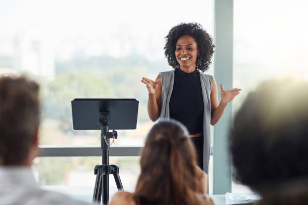Are there any questions? Cropped shot of an attractive young businesswoman speaking at a business conference presentation speech stock pictures, royalty-free photos & images