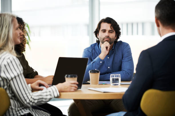 Are you really as present as you think you are? Shot of a group of businesspeople having a meeting in a modern office distracted stock pictures, royalty-free photos & images