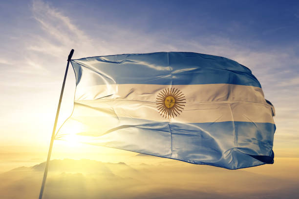 Argentina Argentine Argentinian flag textile cloth fabric waving on the top sunrise mist fog stock photo