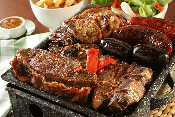 Argentina barbecue "Parrillada" Argentine barbecue make on live coal (no flame), beef "asado" in front, back left "chinchulin" (lamb intestines), back right sausage "Chorizo" and blood sausage "morcilla" argentina food stock pictures, royalty-free photos & images