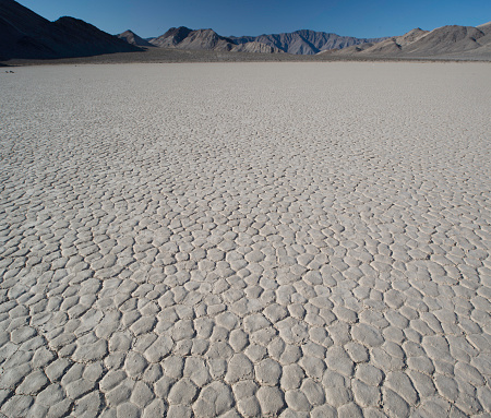 Close up of the patterns of arid, cracked ground in Death Valley.  This square image has lots of copy space, and presents a broad expanse of dry ground, perhaps  a symbol of global warming. 