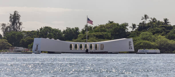 USS Arizona memorial with American flag waving above it Pearl Harbor, Hawaii, USA - September 23, 2018: USS Arizona memorial with american flag waving above it. pearl harbor stock pictures, royalty-free photos & images