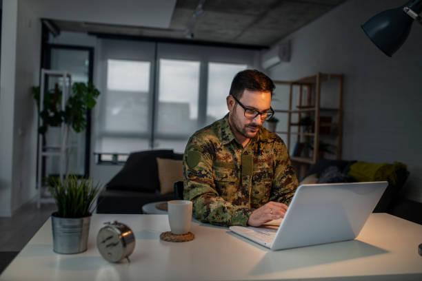 Army man using laptop at home Army man using laptop at home military lifestyle stock pictures, royalty-free photos & images