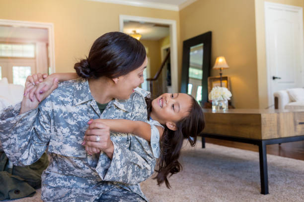 Army mom plays with young daughter Beautiful military mom plays with her young daughter. The woman has just returned from a military assignment. military lifestyle stock pictures, royalty-free photos & images
