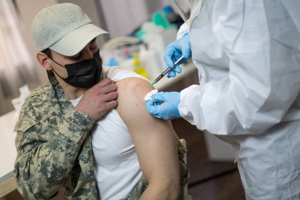 Army soldier in military uniform get covid-19 vaccine stock photo