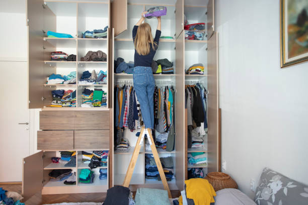 Arranging wardrobe during home isolation Young woman cleanis up the mess in the closet. arrangement stock pictures, royalty-free photos & images