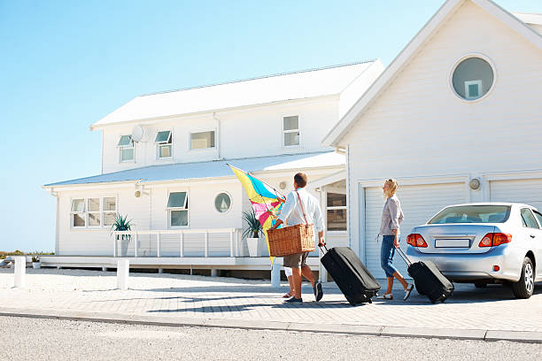 Arriving at their holiday destination Young family arriving at their holiday beach house vacation rental stock pictures, royalty-free photos & images