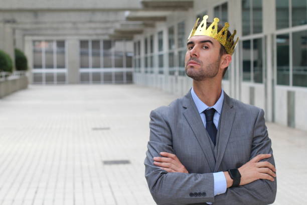 Arrogant businessman with a crown in office space Arrogant businessman with a crown in office space. vanity stock pictures, royalty-free photos & images