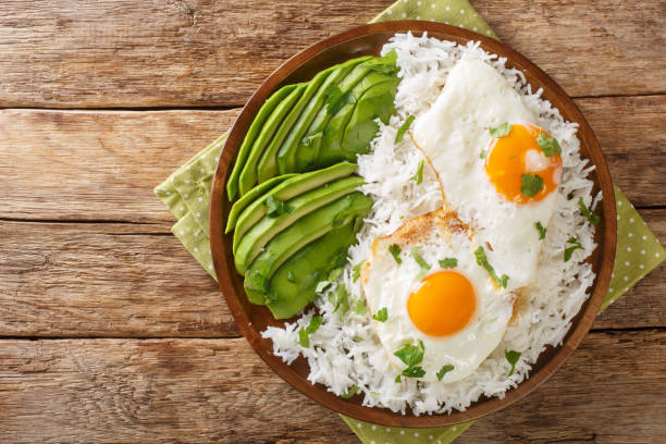 Arroz con huevo frito is white rice and a fried egg close up in the plate. Horizontal top view stock photo