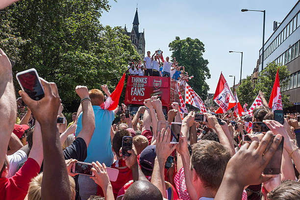 Arsenal FA Cup victory parade London, UK - May 18, 2014 : Arsenal Football Club's victorious 2014 FA Cup winning team parading the trophy around the streets of Islington, from an open topped bus in front of their supporters. Premier League stock pictures, royalty-free photos & images