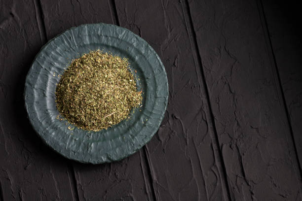Artemisia dracunculus - Dried organic tarragon leaves in bowl stock photo