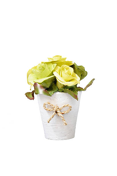 artificial flower in a white flowerpot on white background stock photo