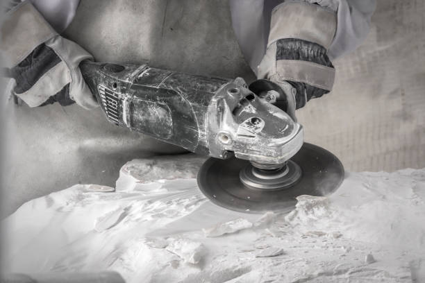 Artist cutting marble stone with angle sander and diamond disc stock photo