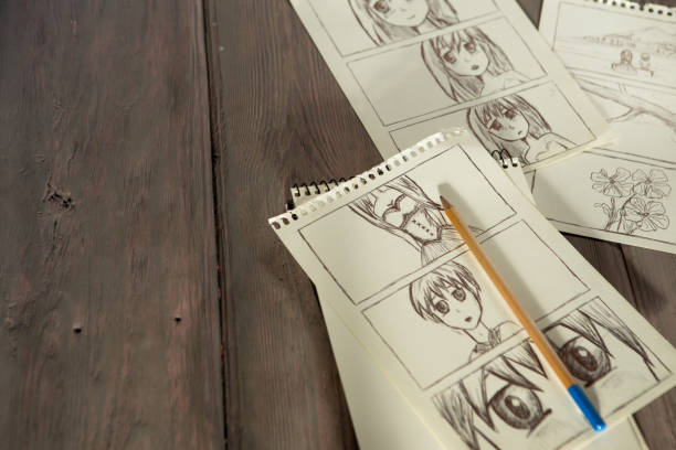 Artist drawing an anime comic book in a studio. Wooden desk, natural light stock photo