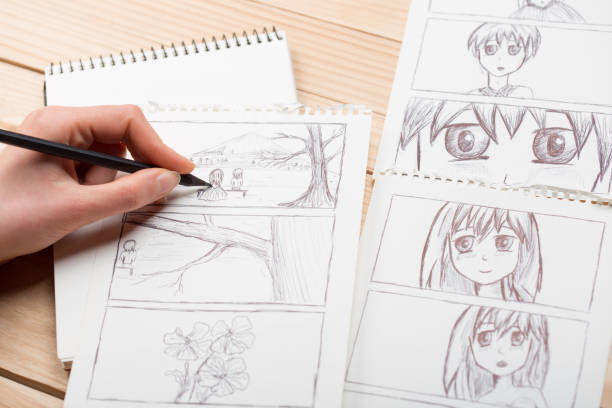 Artist drawing an anime comic book in a studio. Wooden desk, natural light. Creativity and inspiration concept. stock photo