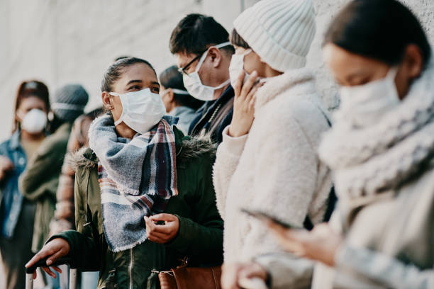 As long as we're together we'll get through this Shot of a young man and woman wearing masks while travelling in a foreign city crowded stock pictures, royalty-free photos & images