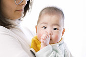 アジアの赤ちゃんは抱きしめて指を吸う