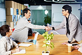 握手を交わすアジアのビジネスの人々