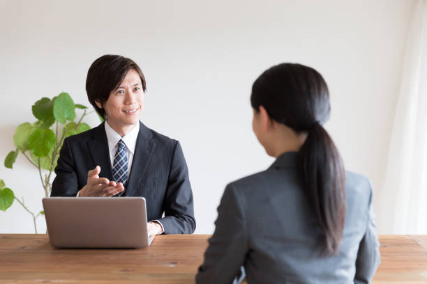 事務所で話をアジアのビジネス人 - インタビュー　日本人 ストックフォトと画像