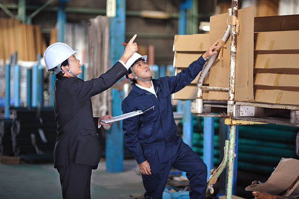 Asian Businessman Checking Inventory in a Warehouse stock photo