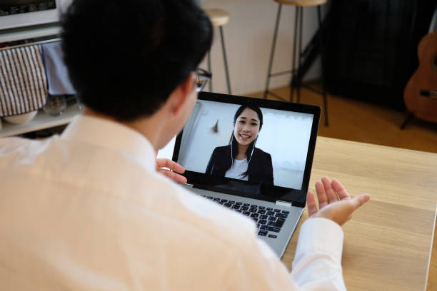 aziatische zakenman die aan collega op webvergadering spreekt - interview stockfoto's en -beelden