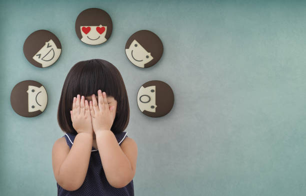 Asian child girl with green concrete wall background, Feelings and emotions of kid Portrait of a little girl covering her face and 3d rendering of emotion icons emotion stock pictures, royalty-free photos & images