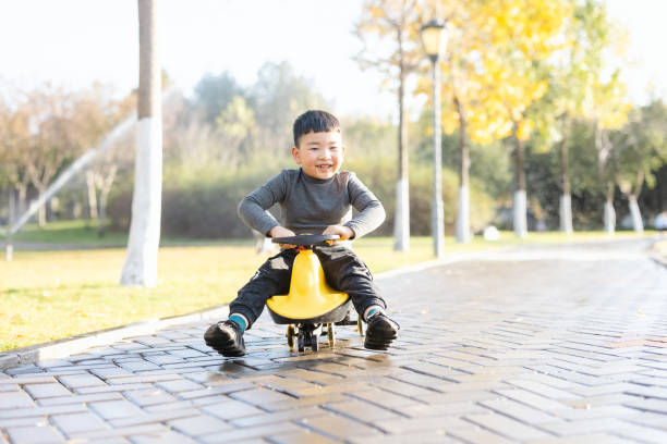asian child riding he swing car stock photo