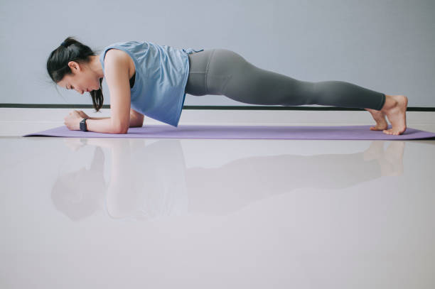asian chinese beautiful woman with yoga pants doing plank position in living room  asian yoga pants stock pictures, royalty-free photos & images