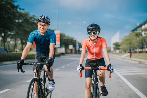 asian chinese couple cyclist enjoy road biking cycling during weekend morning together