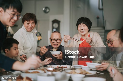 istock Asian chinese family chinese new year reunion dinner having traditional dishes at dining table 1291474734