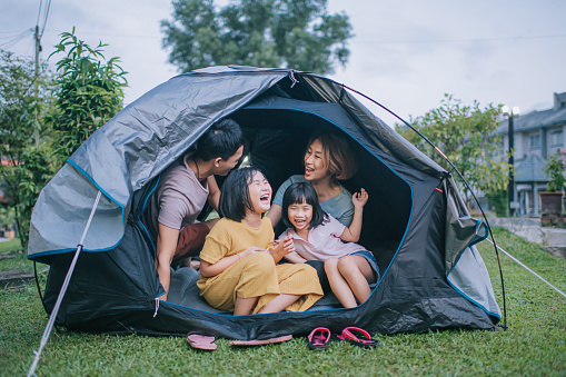 Asian chinese family playing bonding inside camping tent  at backyard of their house staycation weekend activities