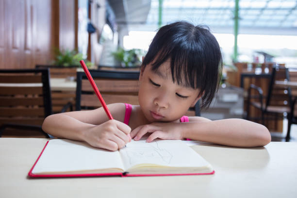 Asian Chinese little girl doing homework stock photo