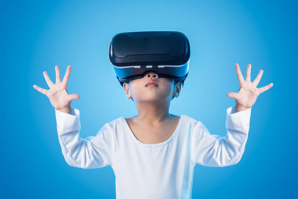 Asian Chinese little girl experiencing virtual reality eyeglasss stock photo