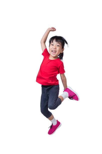 Asian Chinese little girl jumping up and wave her hands stock photo