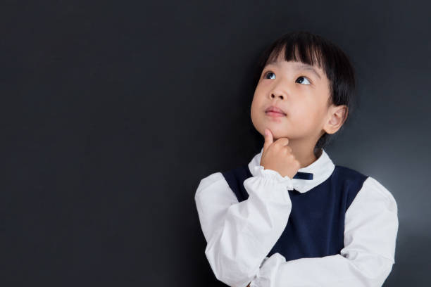 Asian Chinese little girl standing in front of blackboard stock photo