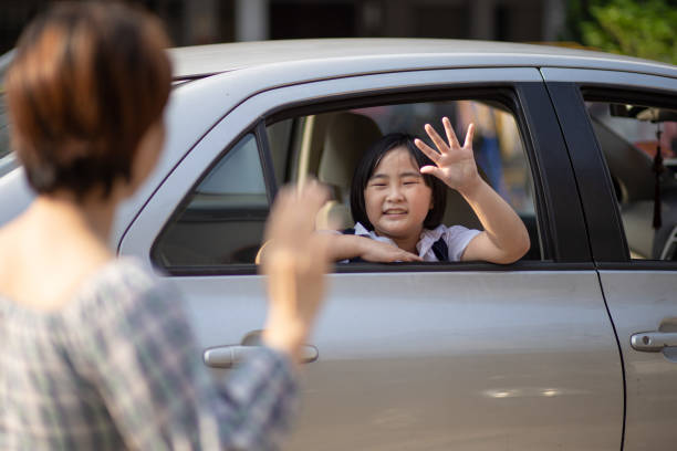 Asian Chinese mother say goodbye  to her children back to school at car in morning.  wave goodbye asian stock pictures, royalty-free photos & images