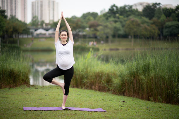 người phụ nữ mang thai châu á trung quốc tập yoga tại công viên công cộng - mang thai hình ảnh sẵn có, bức ảnh & hình ảnh trả phí bản quyền một lần
