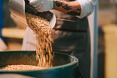 istock asian chinese working senior man scooping raw coffee beans from bucket to weighing machine and blending it for coffee roasting process in factory warehouse 1333323852