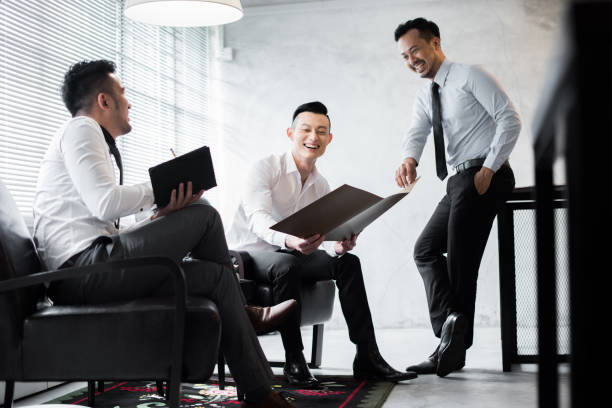 Asian colleagues discussing work in the office stock photo
