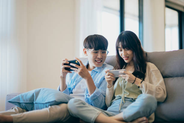 asian couple lovers enjoy and play console game on vacation make more quality time of happiness together at home - taiwan 個照片及圖片檔