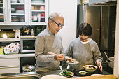 キッチンで食べ物を準備するアジアのカップル
