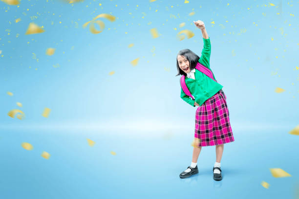 Asian cute girl with a backpack and excited expression standing Asian cute girl with a backpack and excited expression standing over blue background philippines girl stock pictures, royalty-free photos & images