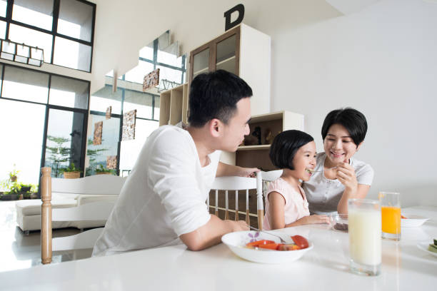 Asian family eating a healthy snack at home. stock photo