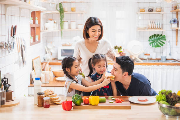 familia asiática disfrutar jugando y cocinando comida en la cocina en casa - healthy dinner fotografías e imágenes de stock