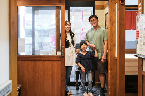 Asian family entering in Japanese restaurant