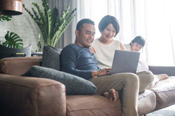 Asian family looking at the computer at home. stock photo