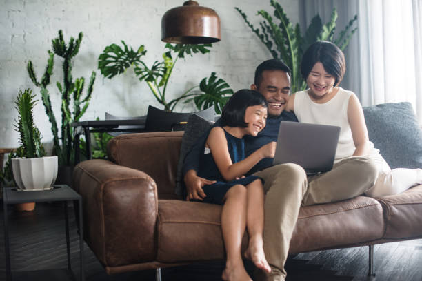 Asian family looking at the computer at home. stock photo