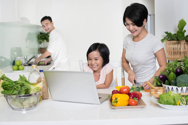 Asian family looking at the computer together at home. stock photo