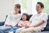 ソファで微笑むアジアの家族